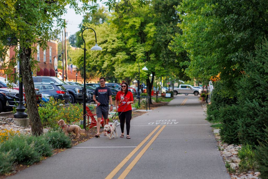 Couple walking dog along bike trail